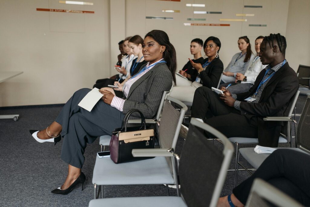 A diverse group of adults engaged in a business seminar, showcasing active listening and participation.
